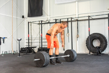 Fototapeta na wymiar Man weightlifting barbell in gym