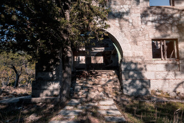 Fototapeta na wymiar Abandoned and demolished old stone building. Selective focus.