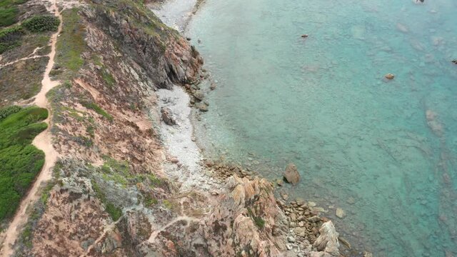 View from above, stunning aerial view of a rocky coastline bathed by a turquoise water. Rena Majore, Sardinia, Italy.
