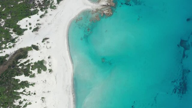 View from above, stunning aerial view of a white sand beach bathed by a turquoise water. Rena Majore, Sardinia, Italy.