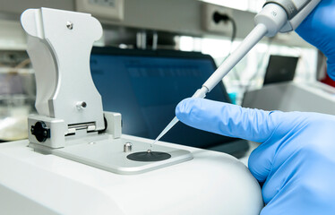 Scientist loads sample onto the low pedestal of Nanodrop in laboratory