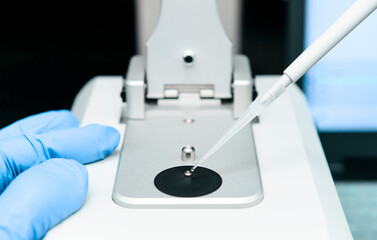 Close-up of loading sample onto low pedestal of Nanodrop by micropipette