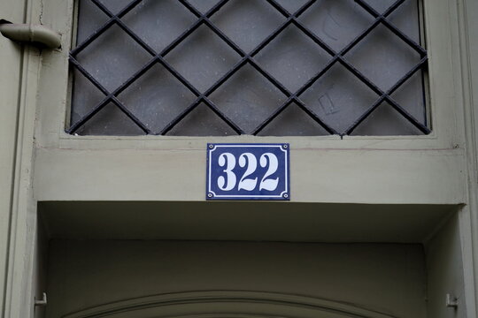 Numéro 322. Plaque de numéro de rue sur façade.