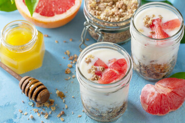 Vegan healthy breakfast. Granola with greek yogurt, honey and grapefruit in a glass.