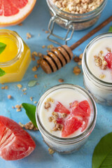 Vegan healthy breakfast. Granola with greek yogurt, honey and grapefruit in a glass.