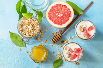 Vegan healthy breakfast. Granola with greek yogurt, honey and grapefruit in a glass. Top view flat lay background.