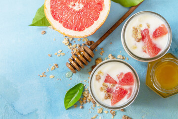 Vegan healthy breakfast. Granola with greek yogurt, honey and grapefruit in a glass. Top view flat...