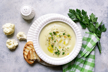 Cauliflower creamy soup with potatoes and cheese. Top view with copy space.