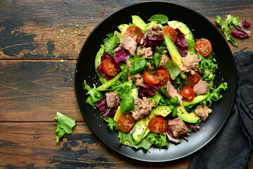 Tuna salad with tomatoes and avocado. Top view with copy space.