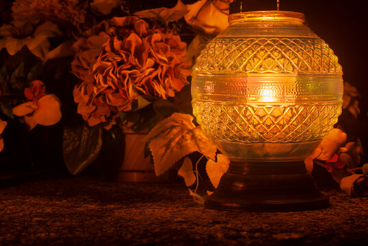 Large round orange grave lantern shining in the dark. Golden light, a symbol of memory.