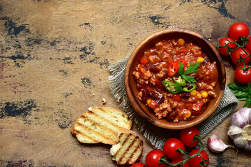 Traditional mexican dish chili con carne - spicy minced meat with vegetables in tomato sauce. Top view with copy space.