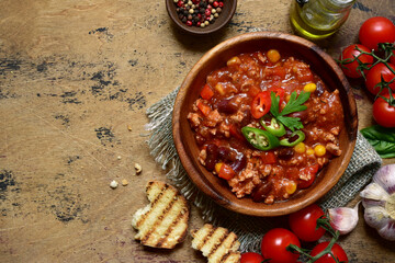 Traditional mexican dish chili con carne - spicy minced meat with vegetables in tomato sauce. Top view with copy space.