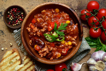Traditional mexican dish chili con carne - spicy minced meat with vegetables in tomato sauce. Top view with copy space.