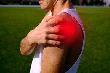 athlete  holding his shoulder due to pain.