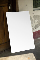 A blank white sign board leaning against a wall, Real shadow, and the background blur