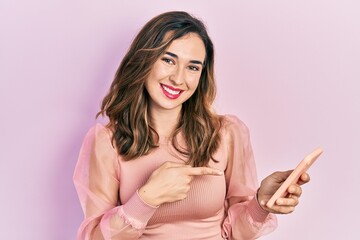 Obraz premium Young hispanic girl having conversation talking on the smartphone smiling happy pointing with hand and finger