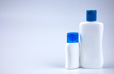 White bottle with blue cap on gray background. Products for packing liquids. Product advertising, empty bottles for packing