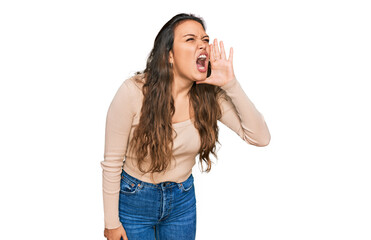 Young hispanic girl wearing casual clothes shouting and screaming loud to side with hand on mouth. communication concept.