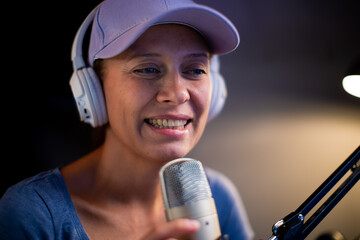 Beautiful Woman In A Cap And White Headphones Leads A Live Stream