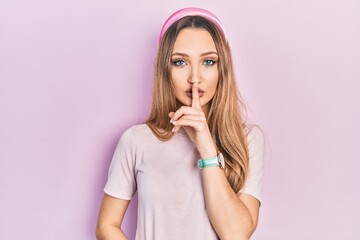 Young blonde girl wearing casual clothes asking to be quiet with finger on lips. silence and secret concept.