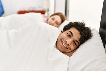 Young couple smiling happy sleeping on the bed at bedroom.