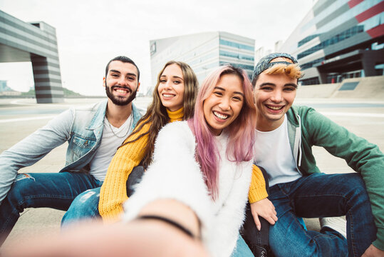 Multiracial group of friends taking selfie in a urban street - Guys and girls having fun walking in the city - Happy millennial people laughing together outside at university campus - Youth concept