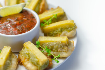 Skinless and boneless battered Alaska Pollock fillet pieces, topped with mushy peas and fried potato