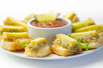 Skinless and boneless battered Alaska Pollock fillet pieces, topped with mushy peas and fried potato