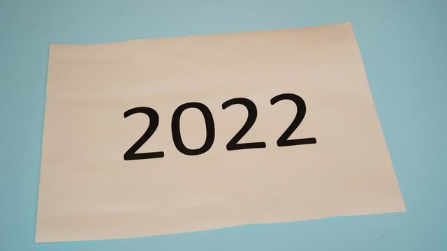 new year's night 2022. A sheet of paper with the year 2021 written on it which is torn up and reopens with the year 2022 written on it