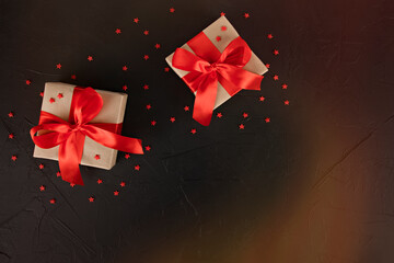 gift boxes with red ribbon and stars on black background