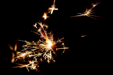 One bengal fire sparkles against the black background.