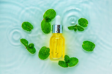 Cosmetics in a bottle in water, skin hydration concept. Selective focus.