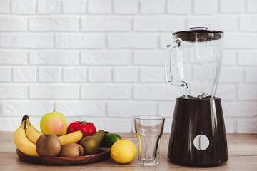 Blender with ingredients for smoothie on table in kitchen