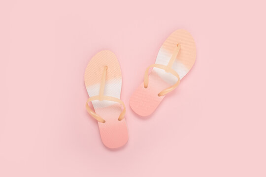 Beach bright flip flops on a pink background. Top view, flat lay.
