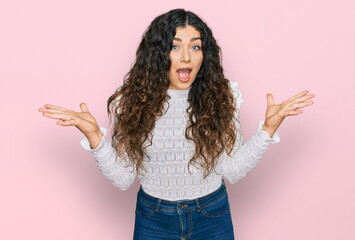 Young hispanic girl wearing casual clothes celebrating victory with happy smile and winner expression with raised hands