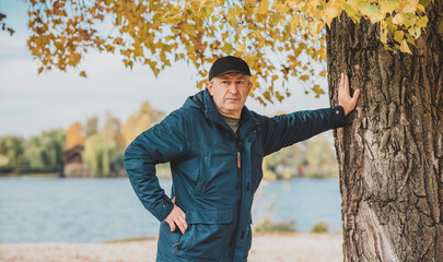 Obraz premium Mature European older man at nature, philosophical portrait, at autumn park