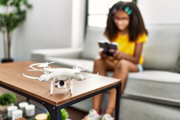 African american girl smiling confident using drone at home