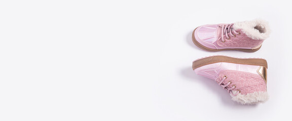 Children's pink shoes on a white background. Top view, flat lay. Banner.