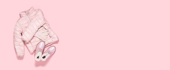 Jacket, gloves and shoes for children for a girl on a pink background. Top view, flat lay. Banner. © Alex