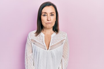Fototapeta premium Middle age hispanic woman wearing casual clothes depressed and worry for distress, crying angry and afraid. sad expression.