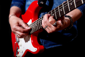 elderly man plays the electric guitar