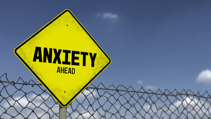 3D-Illustration of a yellow warning sign that says 'ANXIETY AHEAD' in front of a dark sky