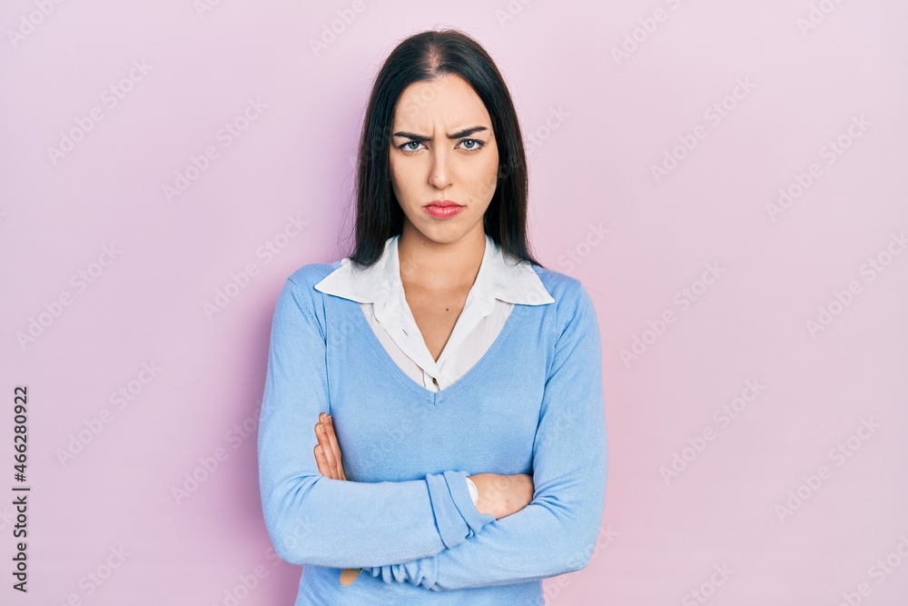 Sticker beautiful woman with blue eyes standing over pink background skeptic and nervous, disapproving expre