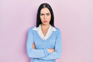 Fototapeta premium Beautiful woman with blue eyes standing over pink background skeptic and nervous, disapproving expression on face with crossed arms. negative person.