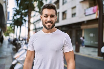 Fototapeta na wymiar Young hispanic man smiling confident walking at street