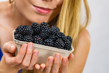 Woman holds blackberry fruits