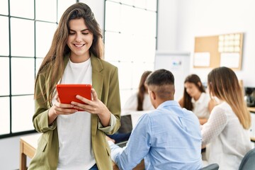 Group of business workers working sitting on the table. Woman smiling happy and using touchpad standing at the office.