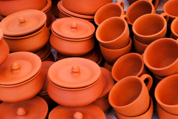 Terracotta, pot, cup kitchen souvenirs pile at street handicraft pottery shop. handmade terracotta Products in handicraft market in Pune, India.