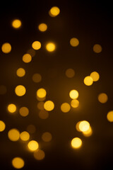 Bokeh golden lights background. Blurred lights festive garland on a black background