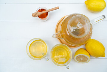 hot afternoon tea with honey and lemon served on table in cafe